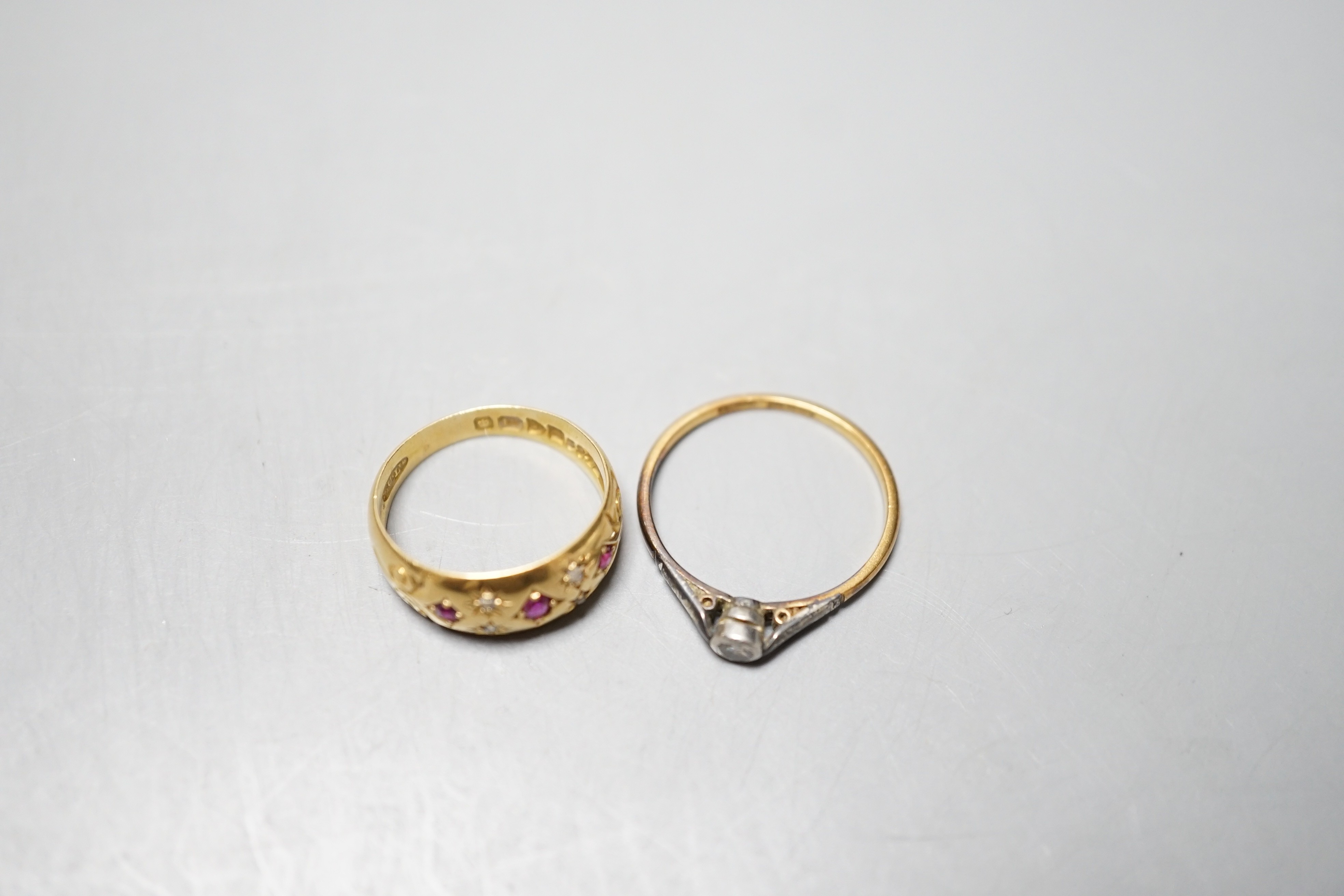 An Edwardian 18ct gold and gypsy set ruby and diamond chip set ring, size J/K and an 18ct and plat. collet set solitaire diamond ring, gross weight 4.8 grams.